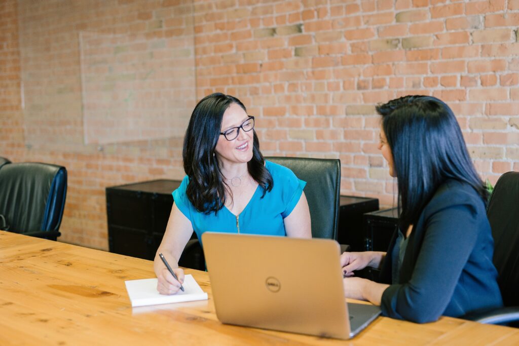 Two women talking at a desk